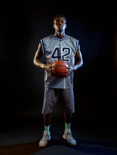 Zaostřený Basketbalista Drží Míč Studiu Černé Pozadí Profesionální Mužský Míč — Stock fotografie