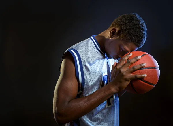 焦点を当てたバスケットボール選手は スタジオでボールをポーズ 黒の背景 スポーツウェアのプロの男性ボールスポーツゲーム 背の高いスポーツマン — ストック写真