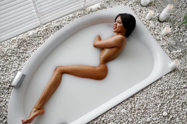 Jong sexy vrouw, ontspanning in bad met melk — Stockfoto