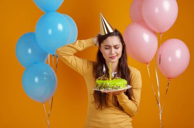 Havai fişekli doğum günü pastası tutan güzel bir kadın.