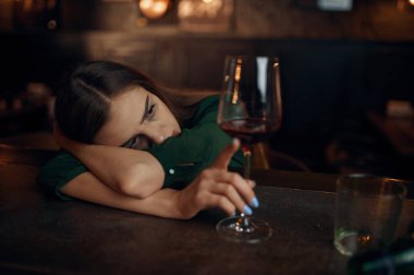 Depresyondaki kadın barda oturmuş, kül tablası dolu. Barda bir kadın, insan duyguları, boş zaman aktiviteleri, depresyon