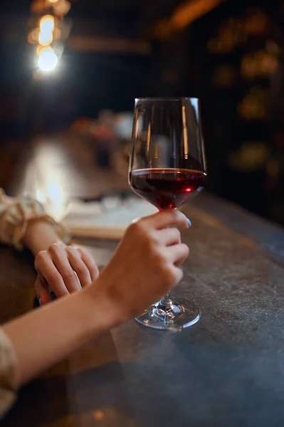 酒吧柜台边坐着一个女人 手里拿着一杯红酒 人类情感 休闲活动 夜生活中的一个女性 — 图库照片