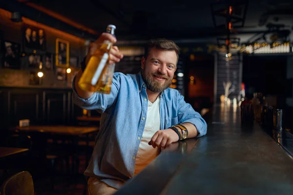 Χαμογελώντας Άνθρωπος Ένα Μπουκάλι Μπύρα Κάθεται Στον Πάγκο Στο Μπαρ — Φωτογραφία Αρχείου
