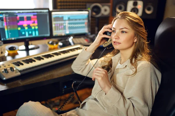 耳机中的女Dj听录音 背景是录音室内部录音 合成器和音频混合器 音乐家工作场所 创作过程 — 图库照片