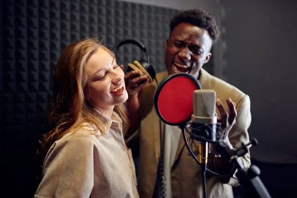 Kulaklıklı Erkek Kadın Şarkıcılar Micriphone Bir Şarkı Söylüyor Arka Planda — Stok fotoğraf