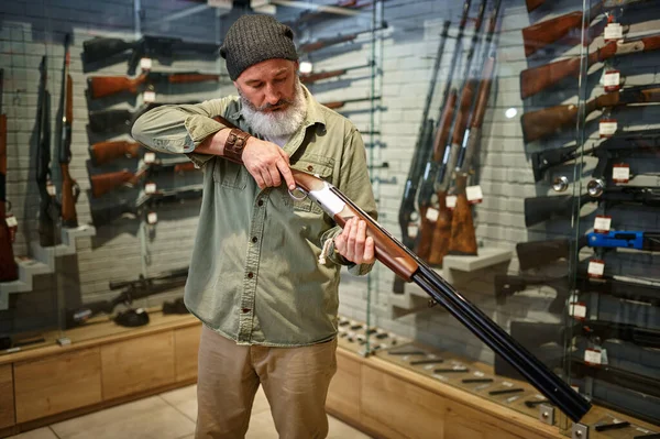 Cazador de hombres barbudos carga rifle en tienda de armas — Foto de Stock