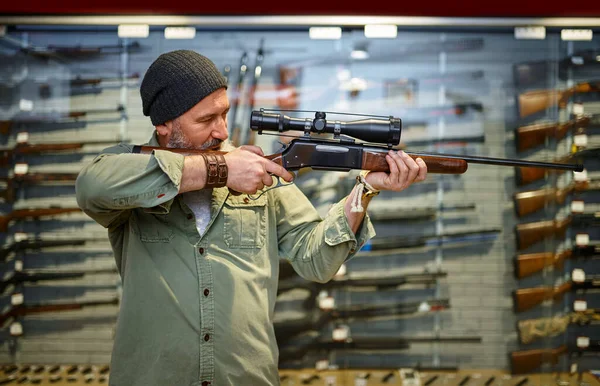 Hunter compra rifle con mira óptica, tienda de armas —  Fotos de Stock