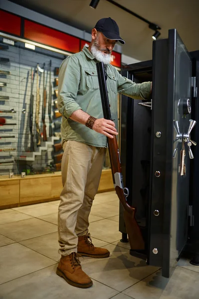 Cazador de hombres barbudos comprando armarios en la tienda —  Fotos de Stock
