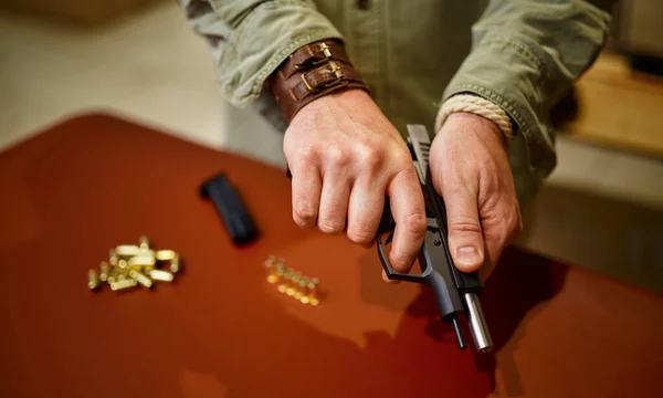 Homem carrega a arma com balas na loja de armas — Fotografia de Stock