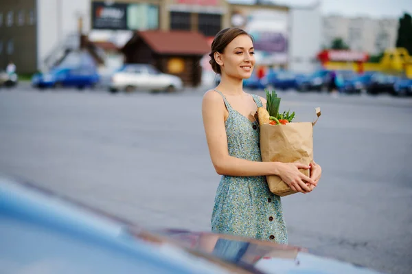スーパーマーケット駐車場の袋を持つ幸せな女性 — ストック写真