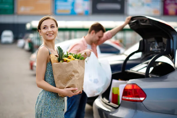 Coppia di famiglie mette i loro acquisti nel bagagliaio — Foto Stock