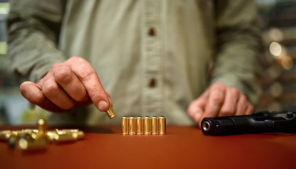 De man plaatst kogels op de toonbank in de wapenwinkel. — Stockfoto