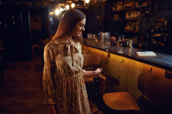 Mulher sozinha com copo de vinho sentada no bar — Fotografia de Stock