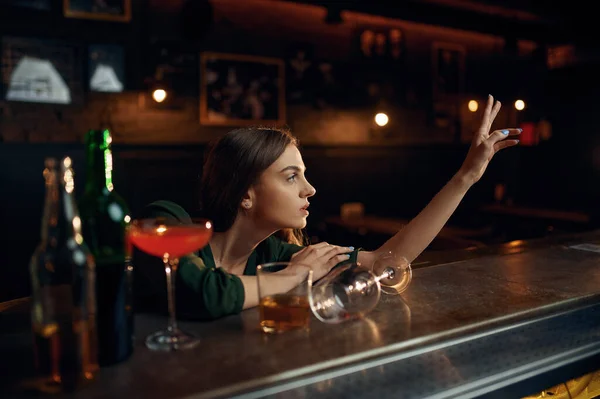 Depressed woman drinks alcohol at counter in bar — Stock Photo, Image