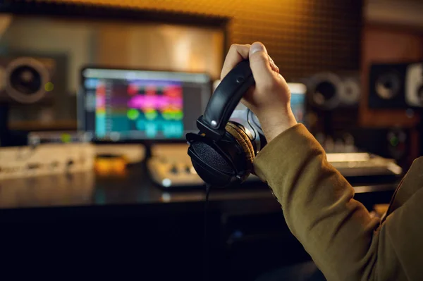 Engineer hand holds headphones, recording studio — Fotografia de Stock