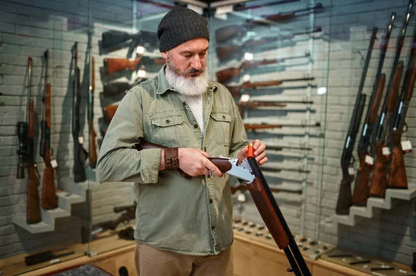 Cazador de hombres barbudos carga rifle en tienda de armas —  Fotos de Stock