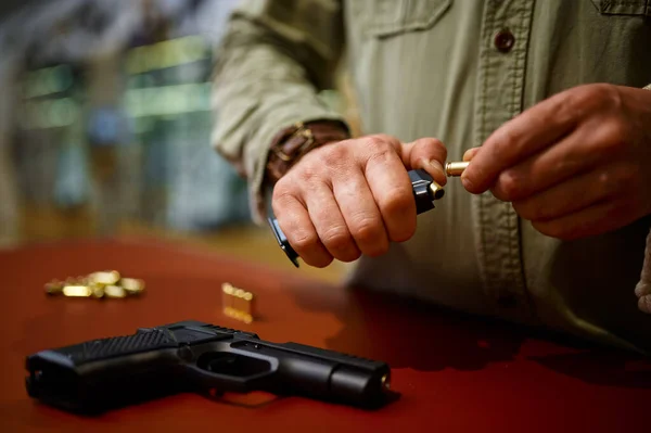 Man loads the magazine with bullets in gun store — Stock fotografie