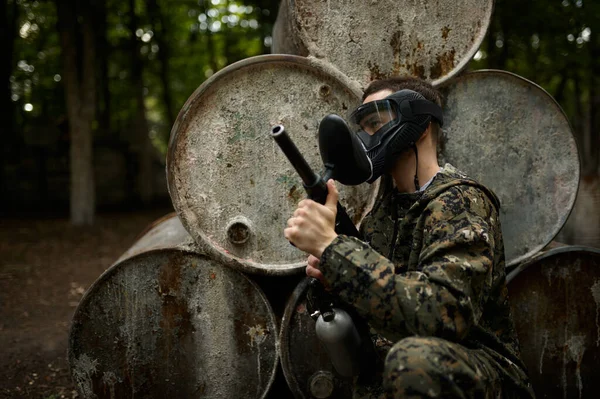 Vrouwelijke krijger in camouflage houdt paintball gun — Stockfoto