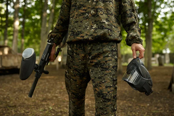 Warrior holds protection mask and paintball gun — Stock fotografie