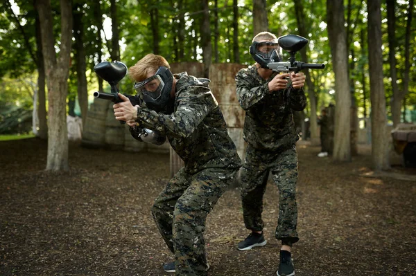 Paintball játékosok egyenruhában és maszkok az erdőben — Stock Fotó