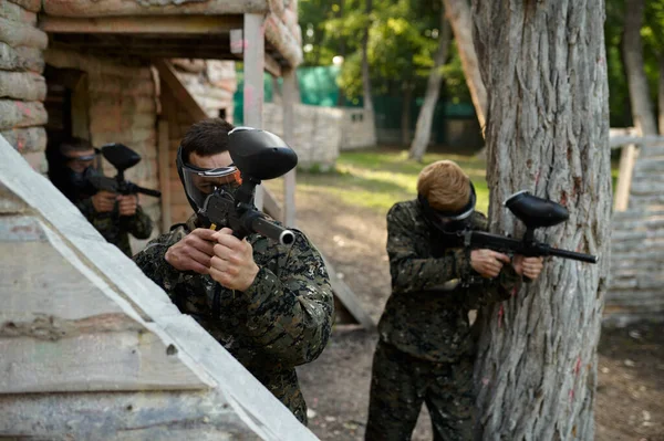 Üniformalı paintball oyuncuları silahla ateş eder. — Stok fotoğraf