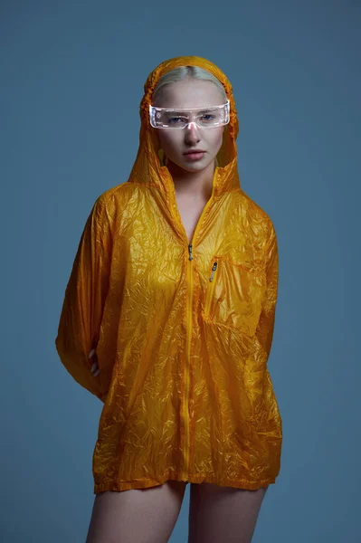 Футуристическая женщина в плаще и современных очках — стоковое фото