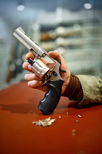 Man reload revolver at the counter in gun store — Stock fotografie