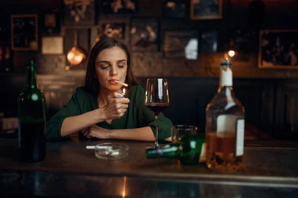 Mujer borracha fuma un cigarrillo en el mostrador en el bar — Foto de Stock