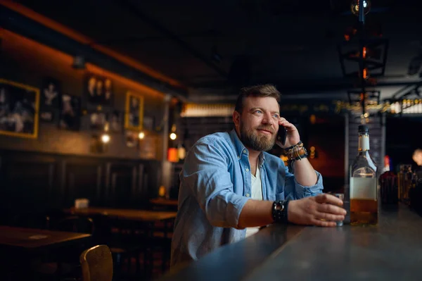 Man talar med mobiltelefon vid disken i baren — Stockfoto