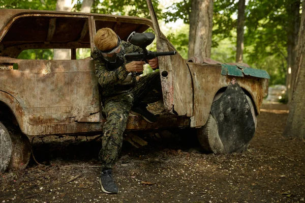 Paintball spelare i uniform och mask i skogen — Stockfoto