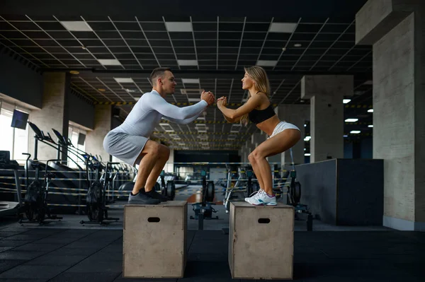 Smal par gör balansövningar på kuber i gymmet — Stockfoto