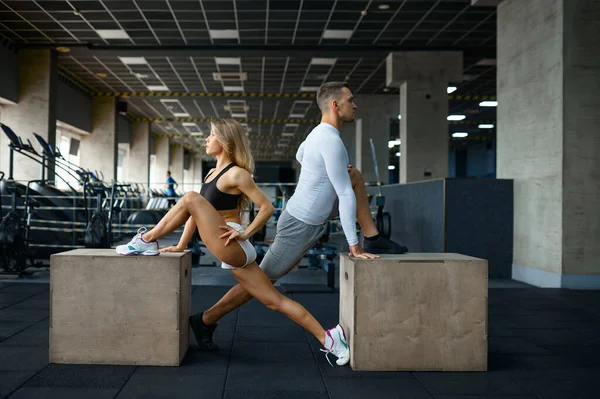 Slim coppia facendo esercizio su cubi in palestra — Foto Stock