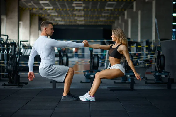 Sportive couple doing push-ups, training in gym — Stock Photo, Image