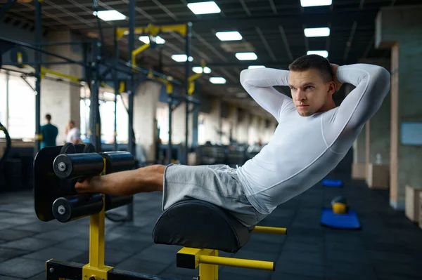 Мускулистый человек делает упражнения пресс, тренировки в тренажерном зале — стоковое фото