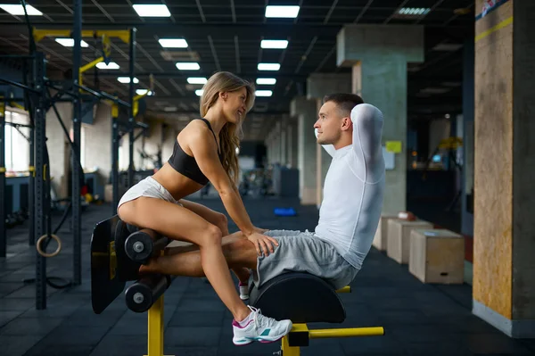 Sportiva kärlek par poser på crunch maskin — Stockfoto