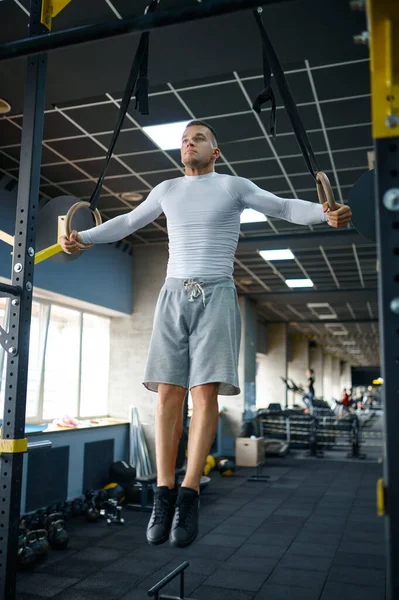 М'язистий чоловік робить вправи на витривалість на кільцях — стокове фото