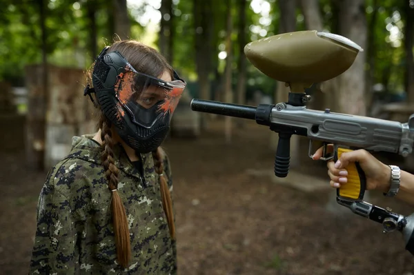 Lövés paintball pisztolyból a lányok arcába maszkban. — Stock Fotó