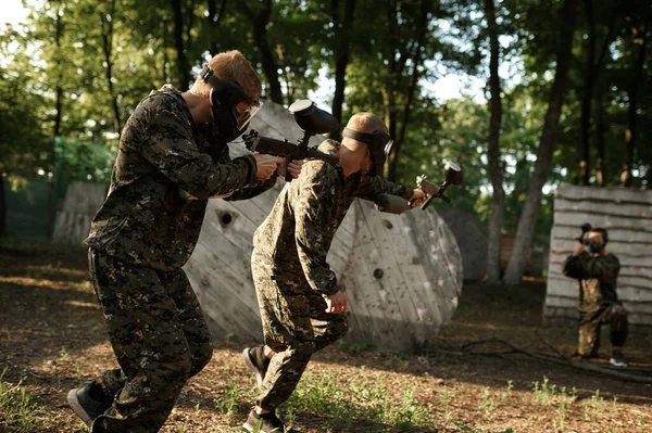 Squadra in uniforme a giocare a paintball nella foresta — Foto Stock