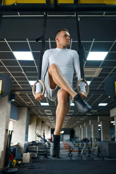 Homem muscular fazendo exercício de resistência nos anéis — Fotografia de Stock