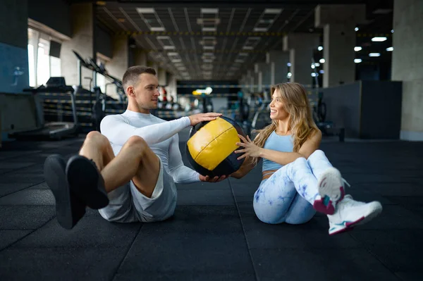 Pár dělá fitness cvičení s míčem v tělocvičně — Stock fotografie