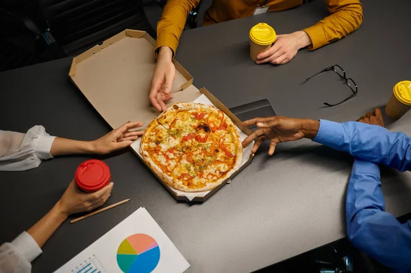 Yöneticiler pizza yer, bilişim ofisinde iş yemeği yer. — Stok fotoğraf