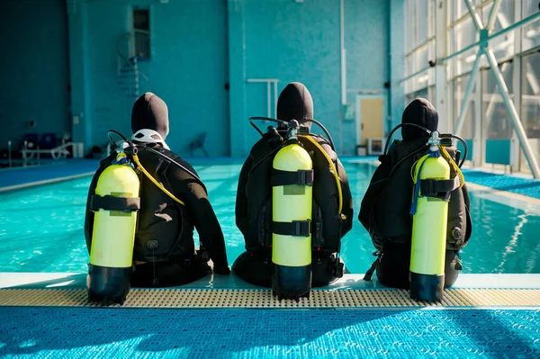 Instructeur et deux plongeurs en costume, vue arrière — Photo