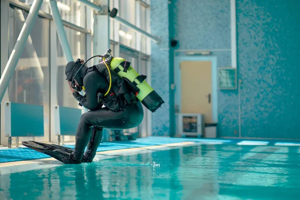 Plongeur masculin en équipement de plongée saute dans la piscine — Photo