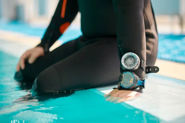 Plongeur masculin en équipement de plongée assis au bord de la piscine — Photo