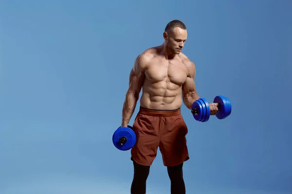 Athlète masculin avec haltères pose en studio — Photo