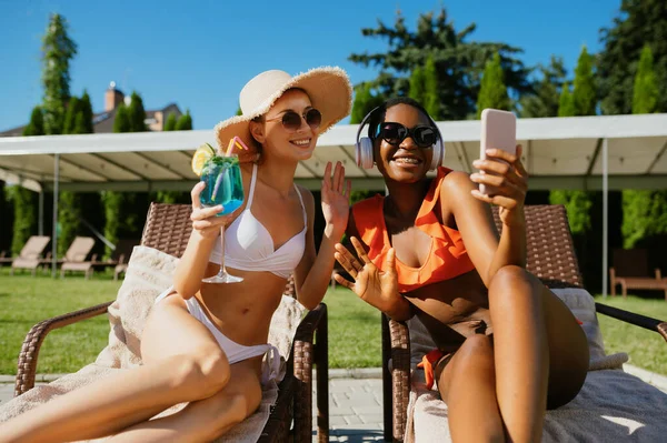 Two girlfriends make selfie on sun beds at pool — Stock Photo, Image