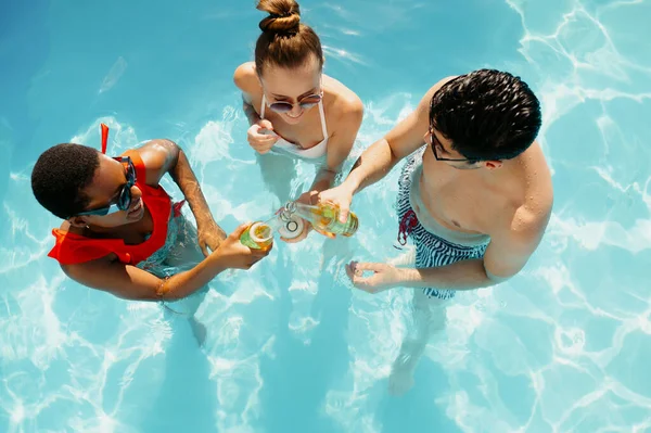 Amigos beben bebidas en la piscina, vista superior —  Fotos de Stock