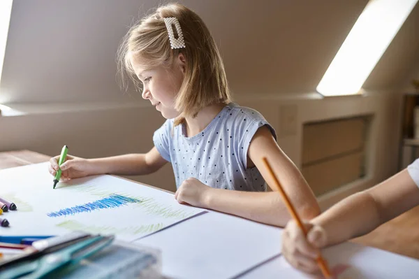 Kleines Mädchen zeichnet mit Filzstiften, Kind in der Werkstatt — Stockfoto