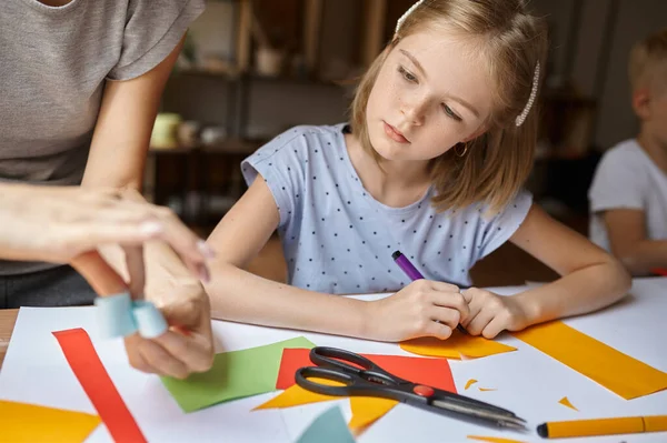 Kleines Mädchen arbeitet in Werkstatt mit buntem Papier — Stockfoto