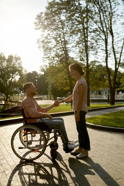 Familienpaar mit Rollstuhl läuft im Park — Stockfoto